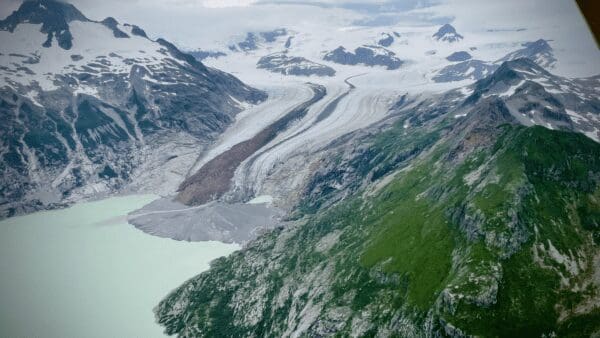 Mountain landscape with glacier and green slopes.