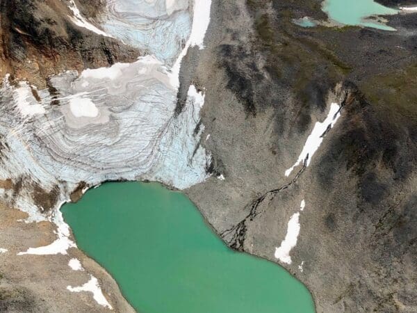 Aerial view of glacier and turquoise lake.