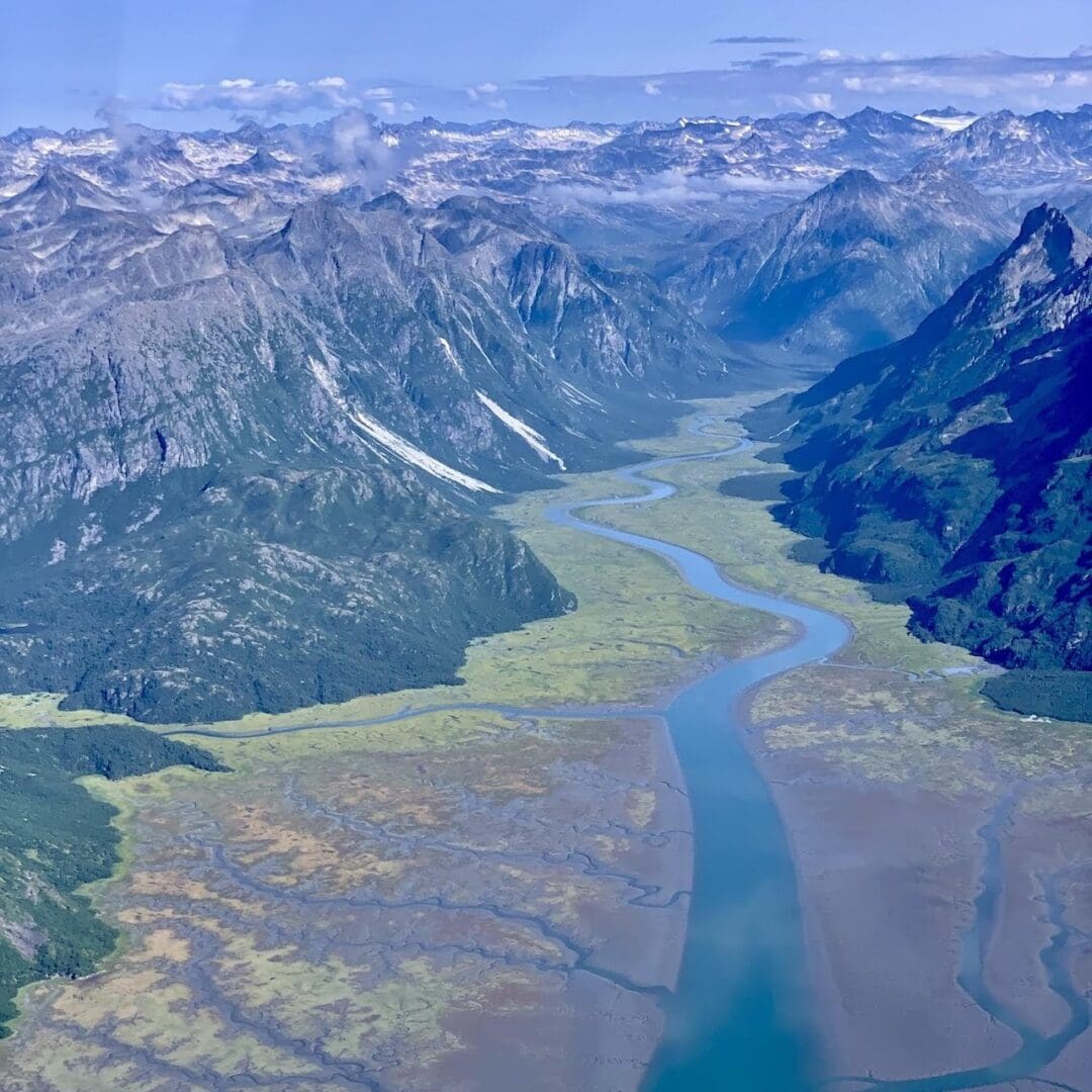 Aerial view of river through mountainous landscape.
