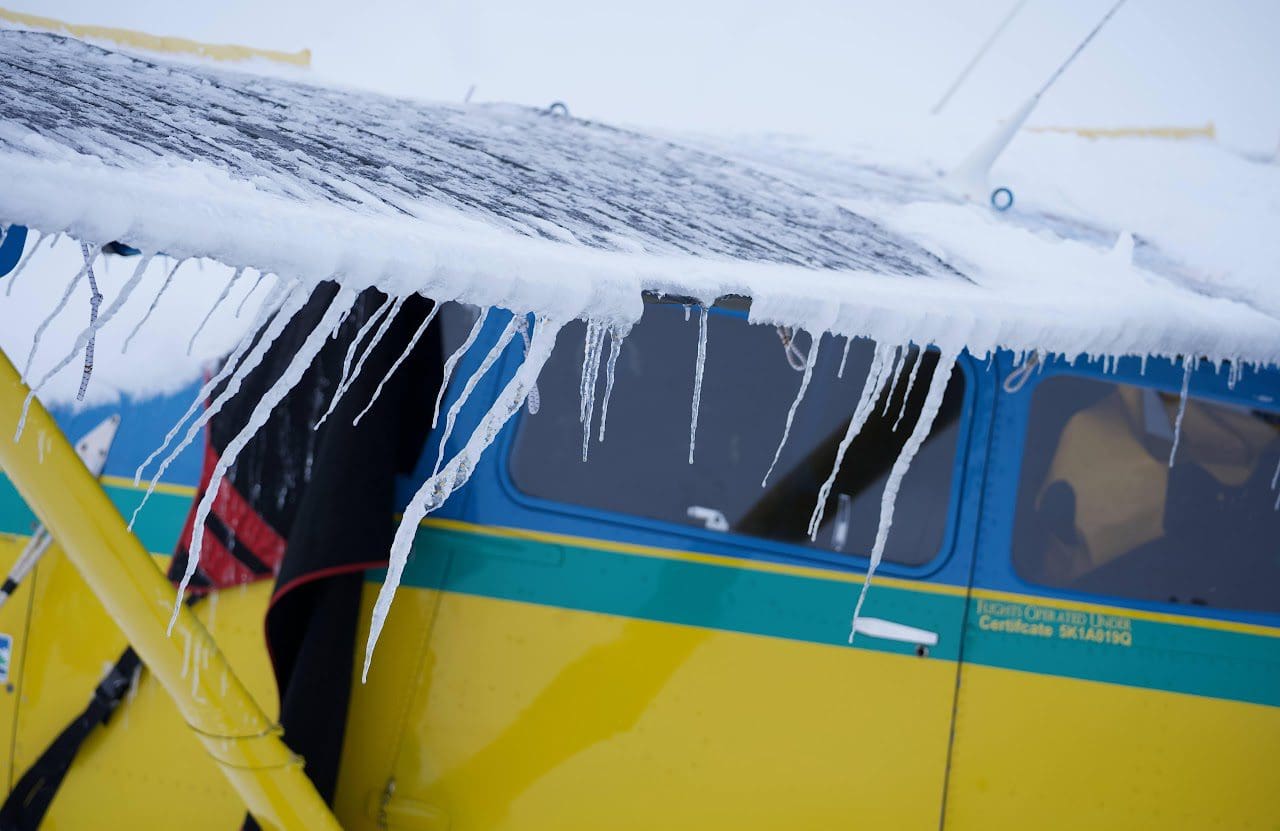 Small airplane with icicles on wing.