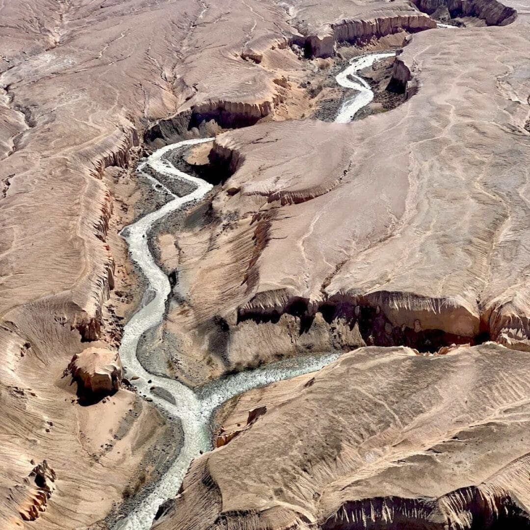 Aerial view of winding desert canyon landscape.