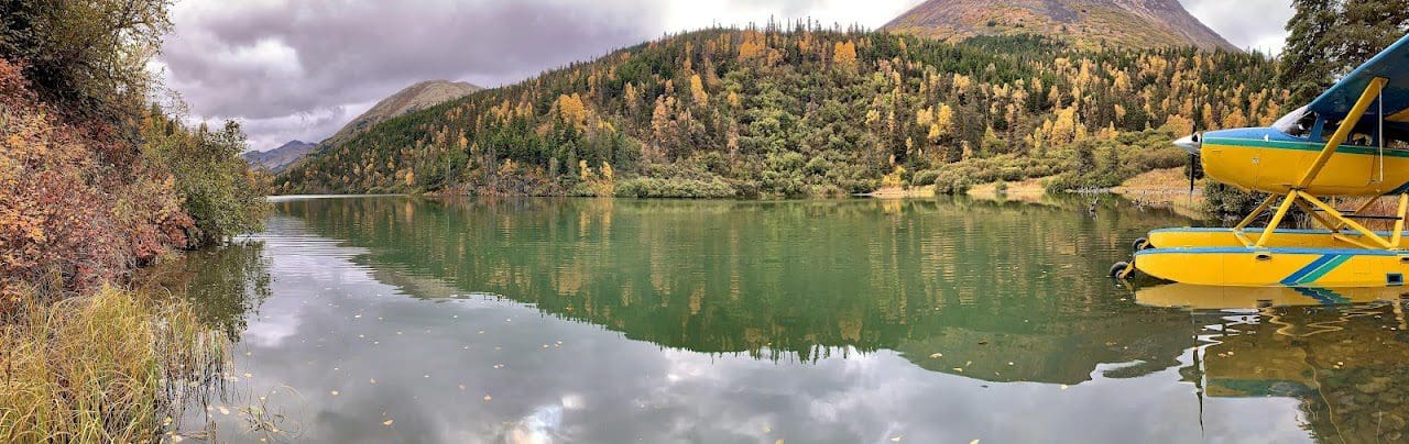 Seaplane beside serene lake and autumn forest.