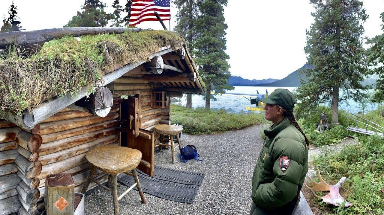 Rustic cabin by lake with park ranger.