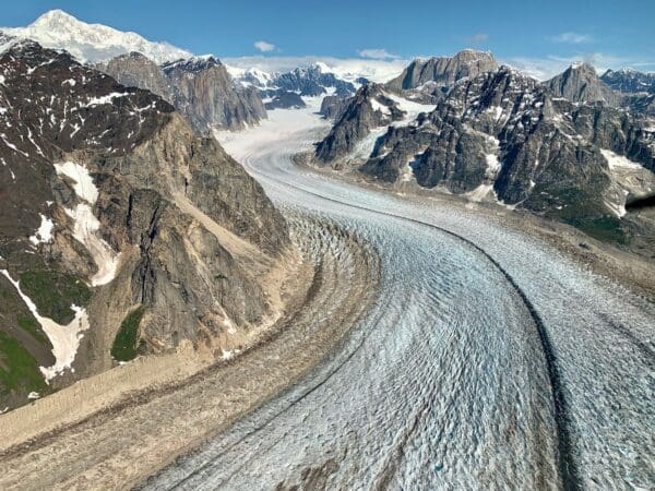 Mountain glacier winding through rocky landscape.