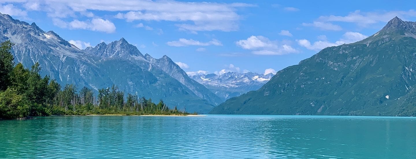 Mountain lake with clear blue water and sky.