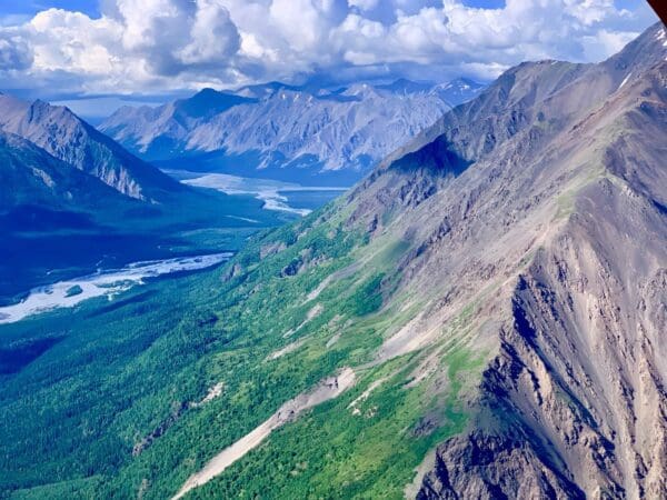 Mountainous landscape with river and clouds.