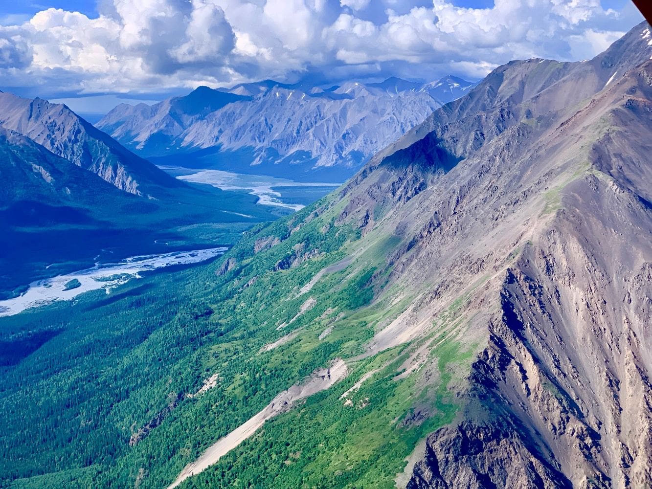Mountainous landscape with river and clouds.