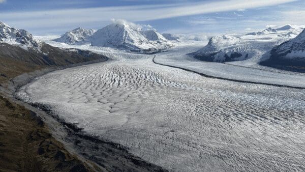 Expansive glacier surrounded by snow-capped mountains.