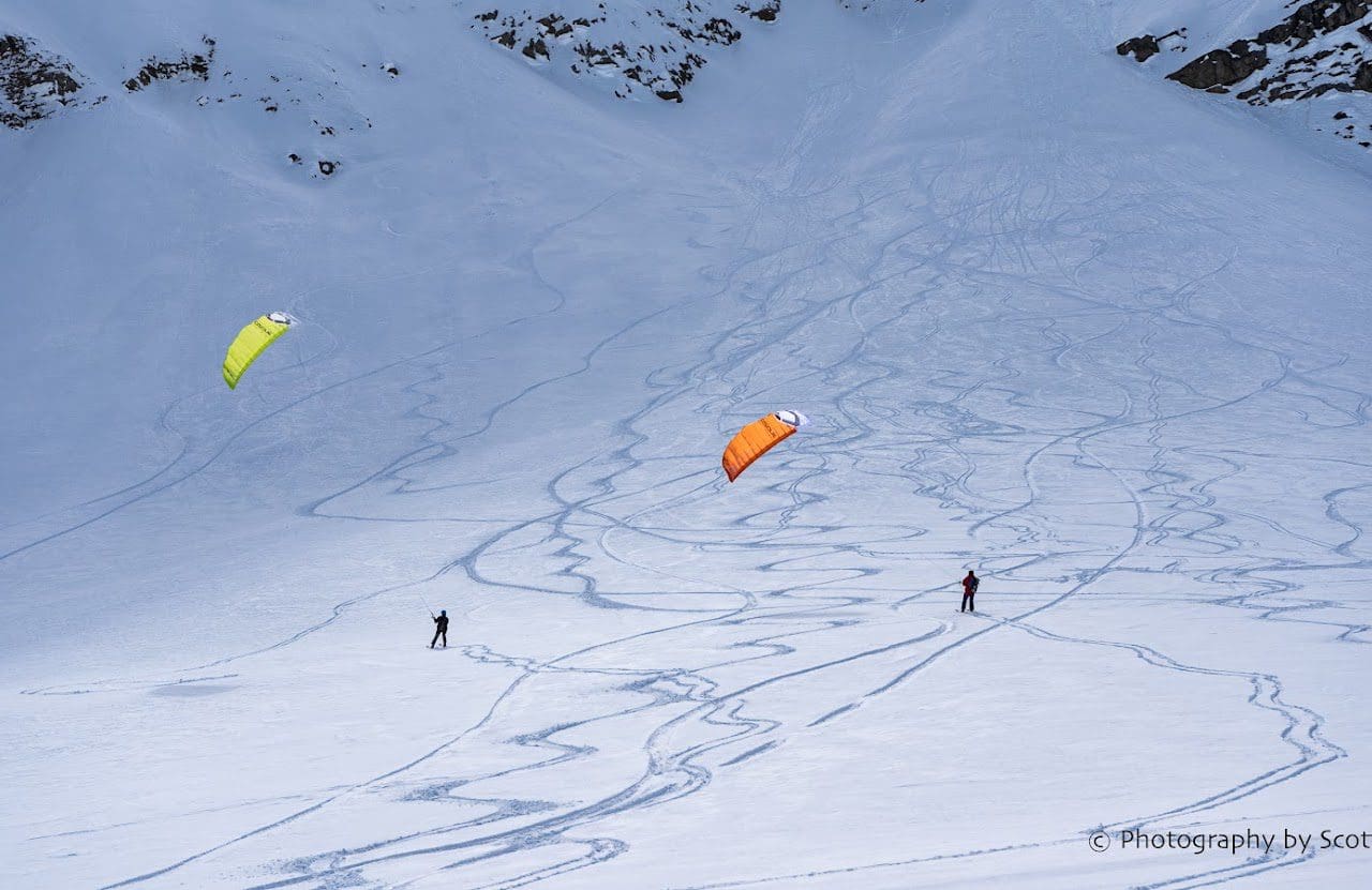 Snowkiting in a snowy mountainous landscape.