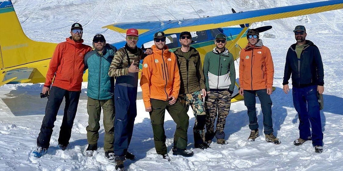 Untitled (4) Group of men standing on snowy terrain.